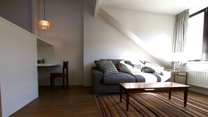 Ein modernes Wohnzimmer mit einer Couch, einem Couchtisch und einem gemusterten Teppich.
