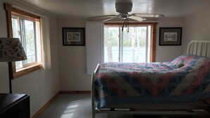 A bedroom with a bed, a ceiling fan, a window, and a dresser. - Enjoy Sunset views on tranquil Dexter Pond (Winthrop)