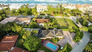Vista aérea de una zona residencial costera con casas, una piscina y vistas al océano.