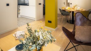 Un interno moderno con zona pranzo, cucina e una parete gialla.