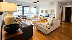 Un salon moderne avec un canapé, une table basse et un grand vase.