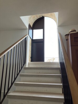 A staircase leading to a dark door with a window above it. - Trulli e Masseria Ianella (Locorotondo (Bari))