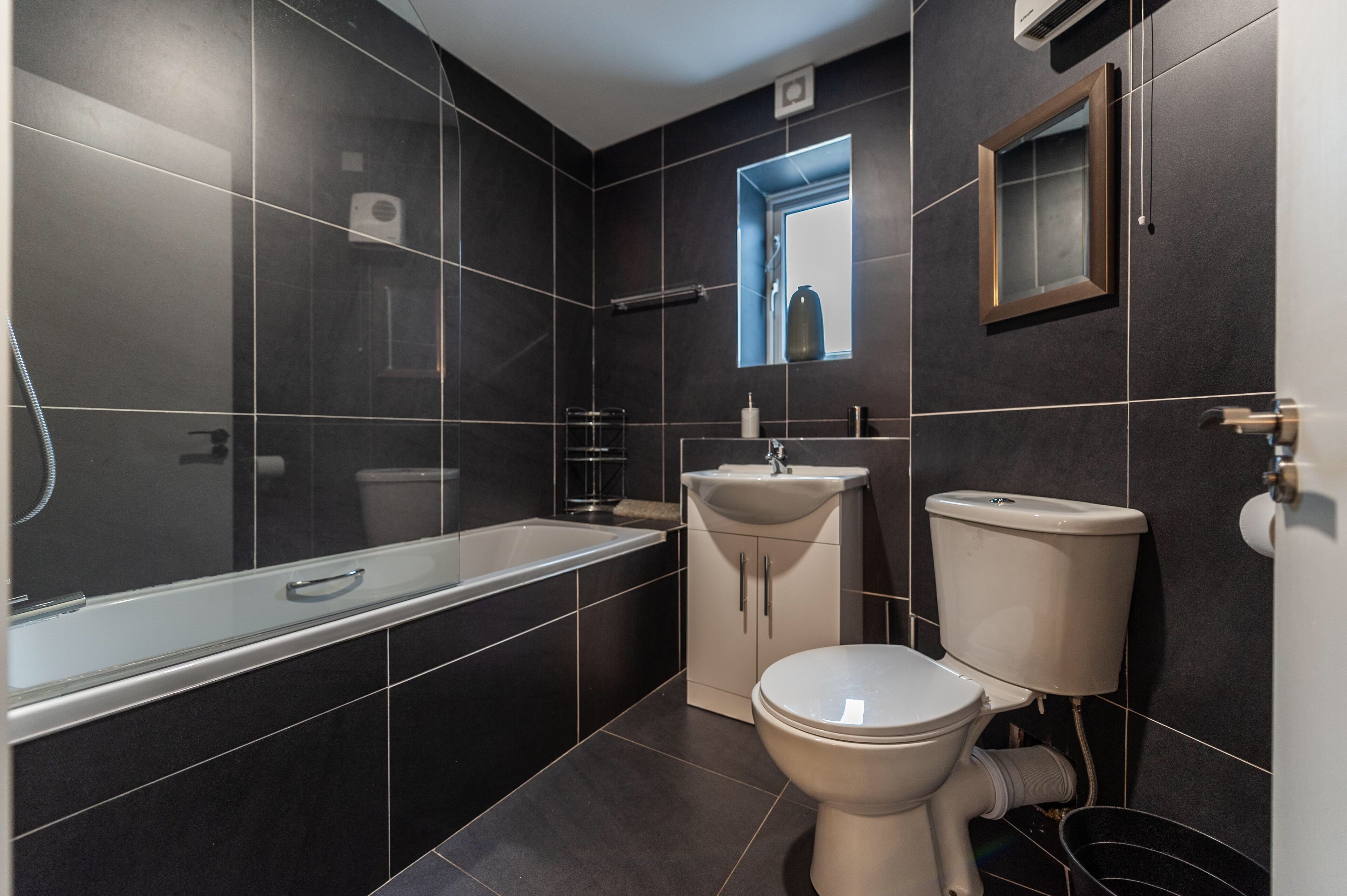 A modern bathroom with a bathtub, sink, and toilet.