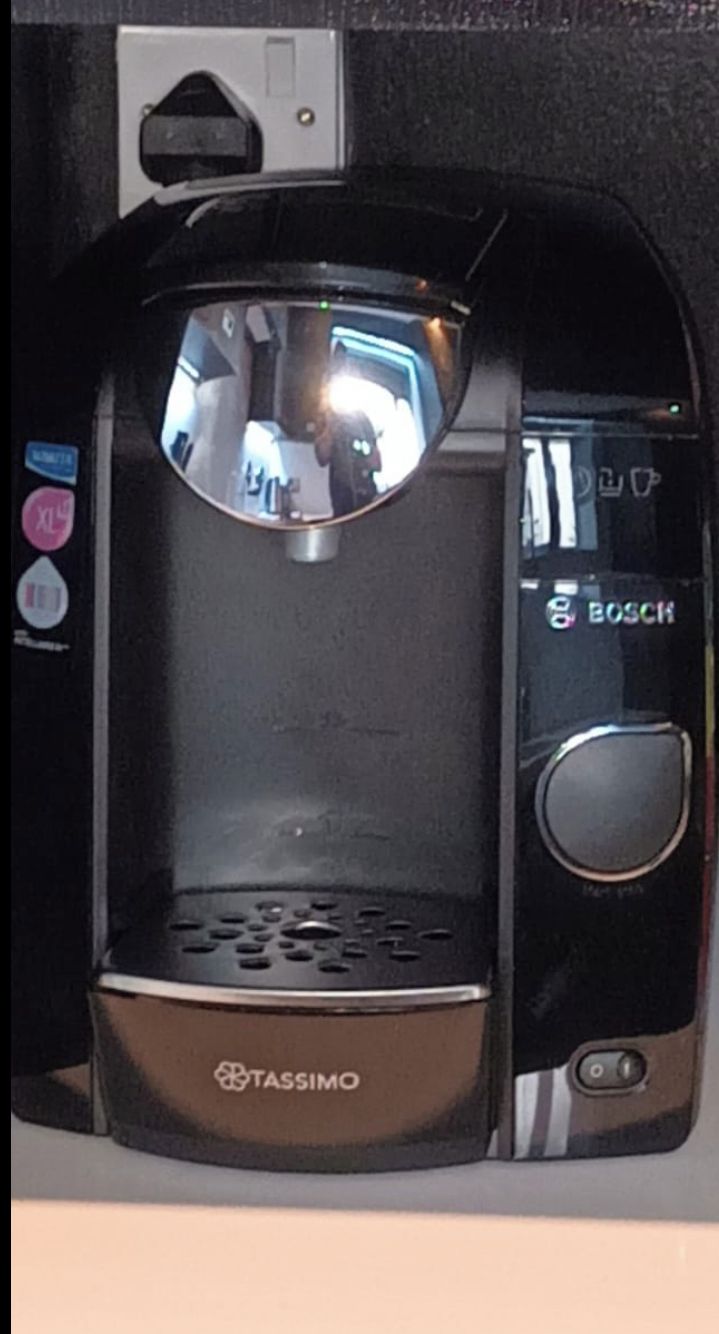 A Tassimo coffee maker with a digital display and a control panel.