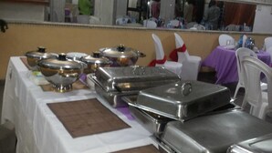 A buffet setup with multiple serving stations, a large mirror, and a tiled floor. - Pridemark Hotel (Abuja)
