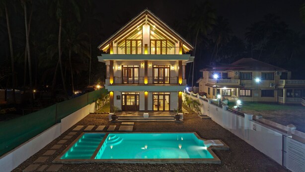 A two-story building with a swimming pool in front. - Private Balinese Style Villa With ZEN Garden and Swimming Pool (Calangute)