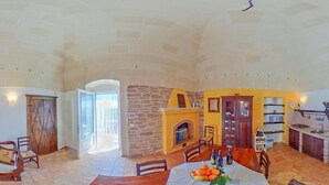 A dining area with a stone fireplace, wooden table, and chairs.