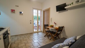 A compact living space with a kitchenette, a dining area, and a sofa. - Marina Timone (Marina di Ragusa)