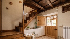 Eine Holztreppe führt zu einem Raum mit einem Fenster, einer Heizung und einem Korb voller Handtücher.