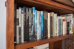 Ein Bücherregal mit einer Auswahl an Büchern, darunter Titel wie 'VITALARI' und 'CASTELLI BASILICI DI COMO'.