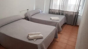 A room with two single beds, each with a pillow and a rolled towel. - Hostal Plaza de España (Salamanca)