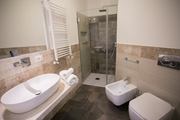 A modern bathroom with a freestanding bathtub, a glass-enclosed shower, and a separate bidet.