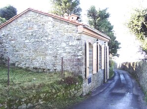 Un bâtiment en pierre avec un toit en pente et une entrée étroite.