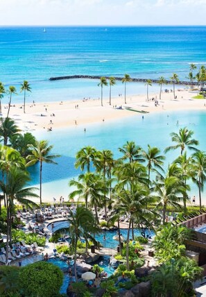 A resort with a beach, pool, and palm trees. - 1519 · Ilikai Collection # 9. Beachfront Resort, upgraded (Honolulu)