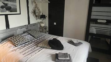 A neatly made bed with patterned bedding, a bedside lamp, and a framed picture on the wall.