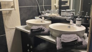 Een badkamer met twee wastafels, een spiegel en een handdoekhouder.