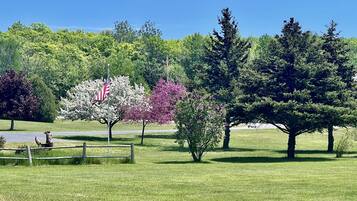 Un parque con un asta de banderola, una valla de madera y varios árboles.