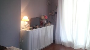 A room with a white cabinet, a lamp, a television, and a curtain. - Villa near the sea, Cinquale Forte dei Marmi (CINQUALE)