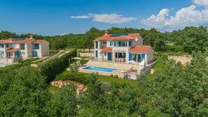 Una gran vila amb piscina, diverses habitacions i jardí.