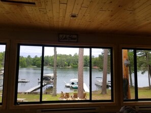 Enjoy serene lake views from the comfort of this cabin, featuring a large window and a cozy atmosphere.