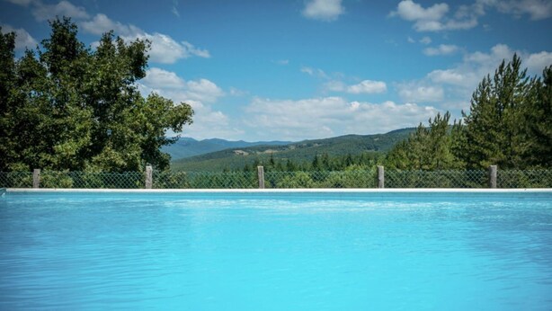 A swimming pool with a view of a forest and mountains in the background. - CastellodiSarna, Montini House (Sarna, Chiusi della Verna)