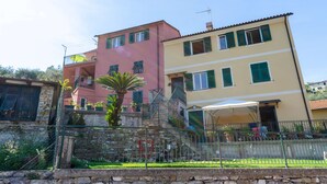 A multi-story building with balconies, a staircase, and a garden area. - Casa Rosa, Rapallo (rapallo)