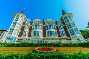 A large, multi-story building with a symmetrical facade, large windows, and a central garden area.