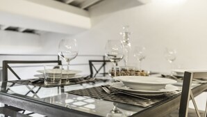 A dining table set with plates, glasses, and cutlery, with a modern metal chair design. - Thebestinrome Luxury Orbitelli (Roma)