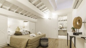 A bedroom with a bed, bedside table, lamp, and a large mirror. - Thebestinrome Luxury Orbitelli (Roma)