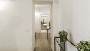 A hallway leading to a bathroom with a sink and mirror. - Thebestinrome Luxury Orbitelli (Roma)