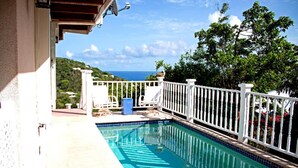 A swimming pool with a white fence, a view of the sea, and a balcony with a white railing. - Spacious, 3 Bed / 3 Bath, Pool, Screened Porch, Wi-Fi, A/C (Cruz Bay, St.John)