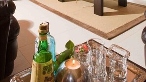 Een gezellige woonkamer met een stenen openhaard, een leren bank en een aan de muur bevestigde televisie.