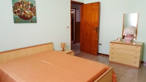 Un dormitorio con cama, cómoda, espejo y una obra de arte en la pared.