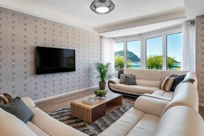 Una sala de estar moderna con un conjunto de sofás, una mesa de centro y un televisor montado en la pared.