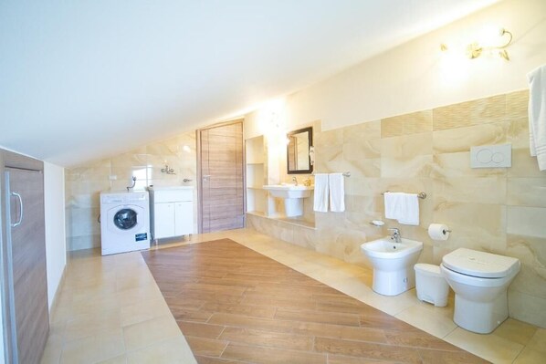 Un baño moderno con lavadora, bidé e inodoro.