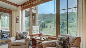 A cozy room with two sofas facing a large window overlooking a scenic landscape.