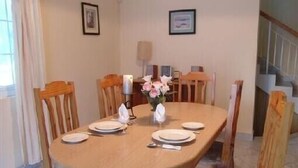 A dining table set with plates, a vase of flowers, and a candle.