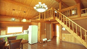 A spacious wooden cabin with a kitchen, dining area, and a staircase leading to an upper level. - Tongyeong Daore Pension (Tongyeong)