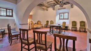 A room with a high arched ceiling, wooden chairs, a table, and a sofa. - Sarna Castle, Portico (Sarna, Chiusi della Verna)