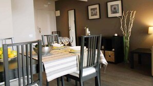 A dining area with a table set for two, chairs, a bowl of fruit, and framed pictures on the wall. - Incredible apartment-central-sea view-near the beach-Free Wifi. (Barcelona)