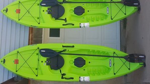 Two bright green kayaks with paddles and life jackets, docked at a building's entrance. - Horny toad point RV space  up above Dolores Colorado book today great view s!  (Dolores)