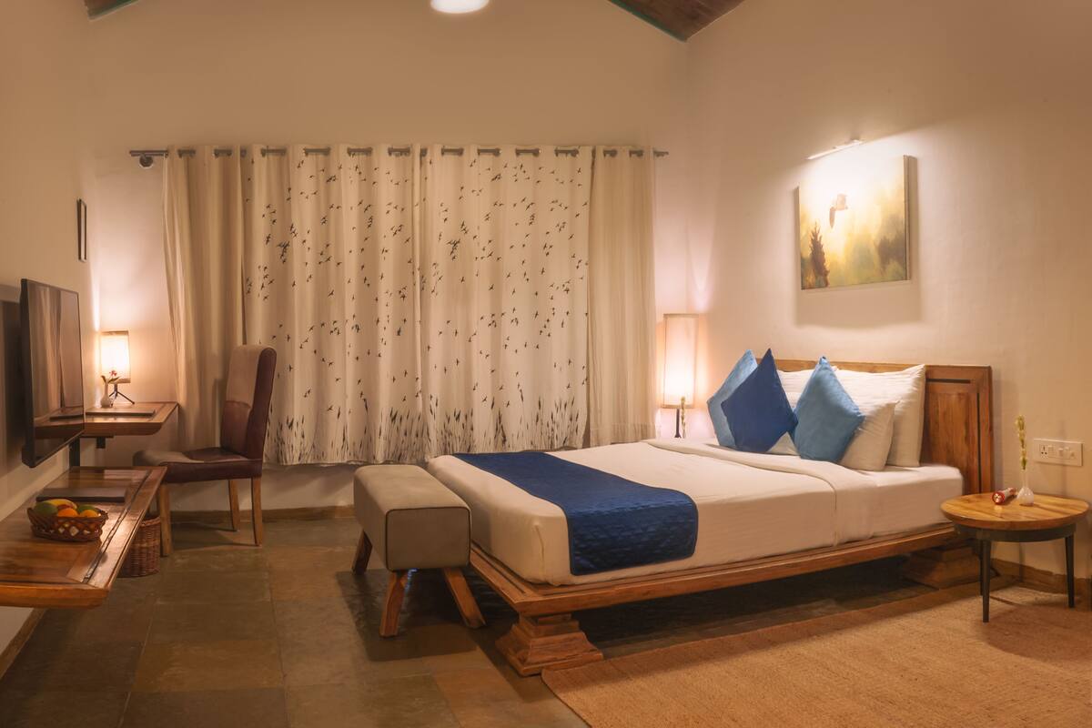 A modern bedroom with a large bed, a desk, and a chair.