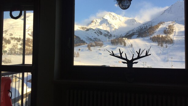 A room with a large window overlooking a snowy mountain landscape. - Brand new apartment with amazing view and close to everything (Sestriere)