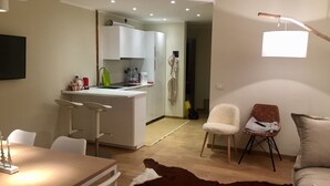 A modern living room with a dining area, a kitchen, and a cozy seating arrangement. - Brand new apartment with amazing view and close to everything (Sestriere)