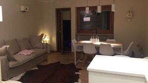 A cozy living room with a sofa, a dining table with chairs, a white cabinet, and a cowhide rug. - Brand new apartment with amazing view and close to everything (Sestriere)