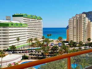 Et hotel med flere etager, et poolområde og udsigt over havet.