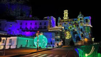 A nighttime street view with illuminated buildings, a large spherical light installation, and a bridge with decorative lights.
