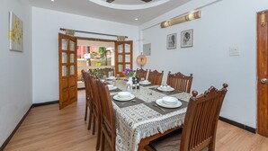 Un comedor con una mesa redonda dispuesta para cuatro personas, rodeada de sillas de madera.
