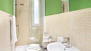 A bathroom with a glass-enclosed shower, a sink, and a mirror. - CARRETAS APARTMENTS MADRID 202 (MADRID)