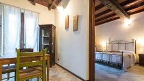 A bedroom with a bed, a wooden chair, a small table, and a cabinet. - Self catering Cà Borgo Vecchio for 3 people (Brusasco)